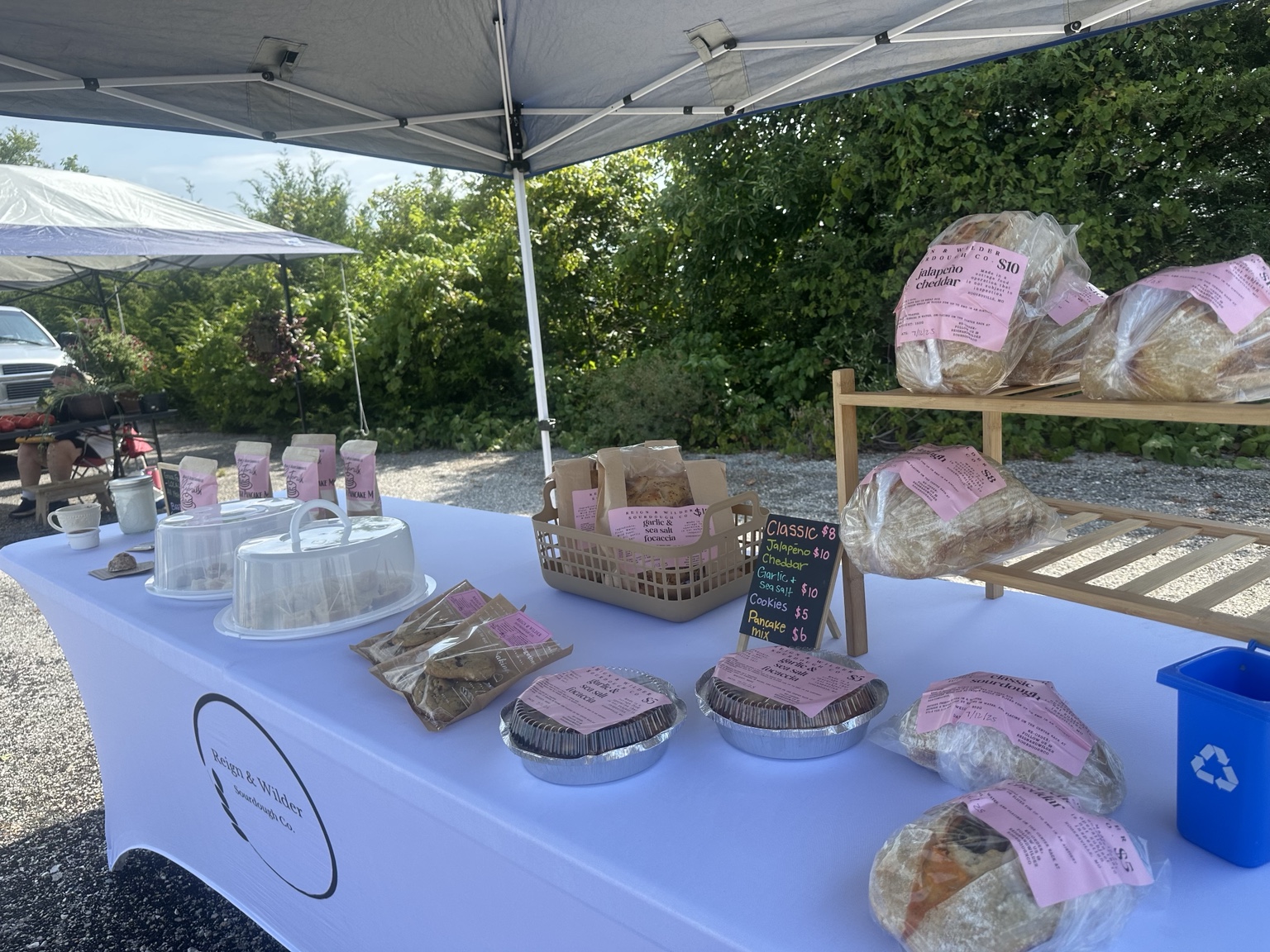 Customers shopping at a local Ozark Missouri market where Reign & Wilder Sourdough Co. is set up selling fresh baked goods
